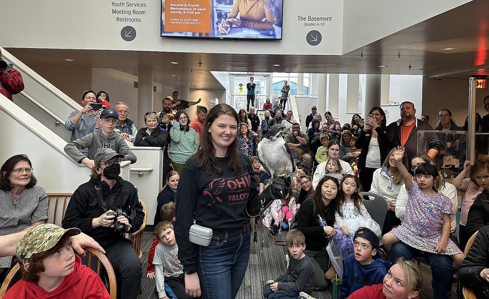 Ohio School of Falconry educator presenting a raptor to a large school audience